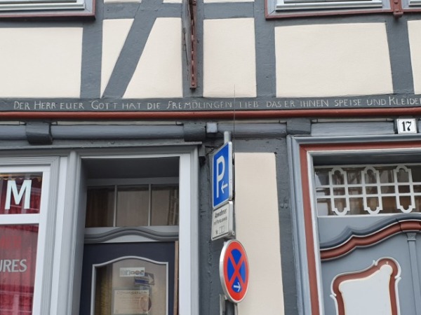 Fachwerfassade. In einen Balken ist ein Bibelvers eingeritzt.